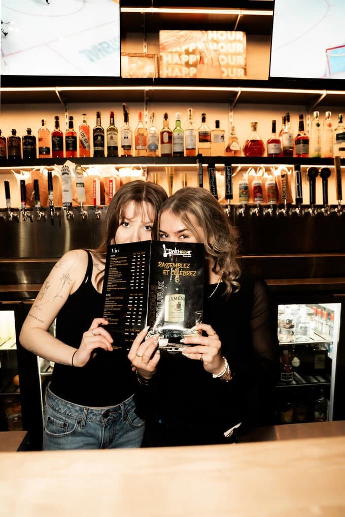 Membre de l'équipe présentant le menu au bar du Balthazar
